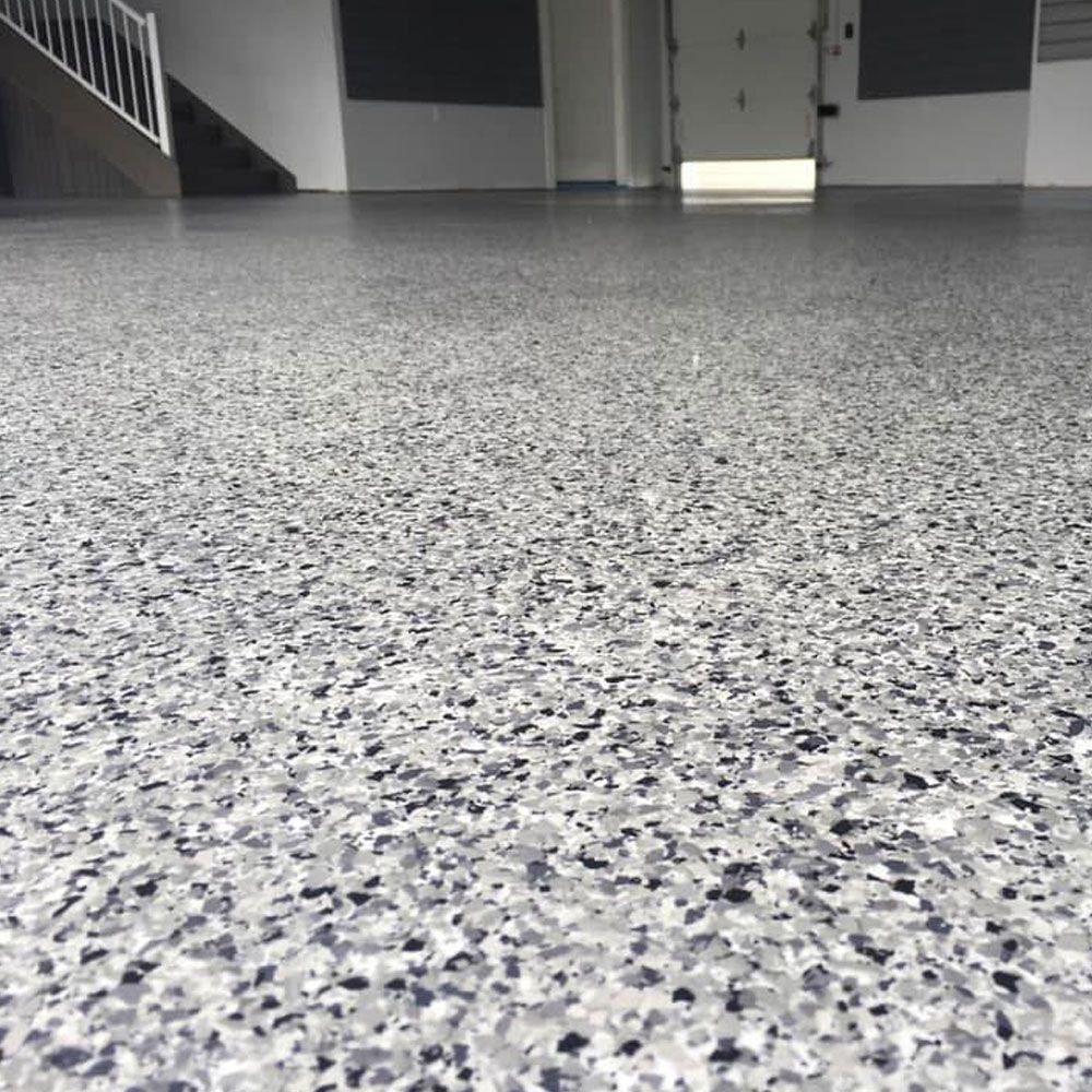 Gros plan sur les flocons gris, blancs et noirs d'un plancher d'époxy