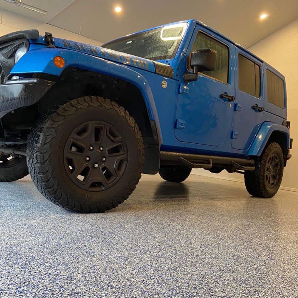 Jeep bleue stationnée sur un plancher de garage en époxy à flocons