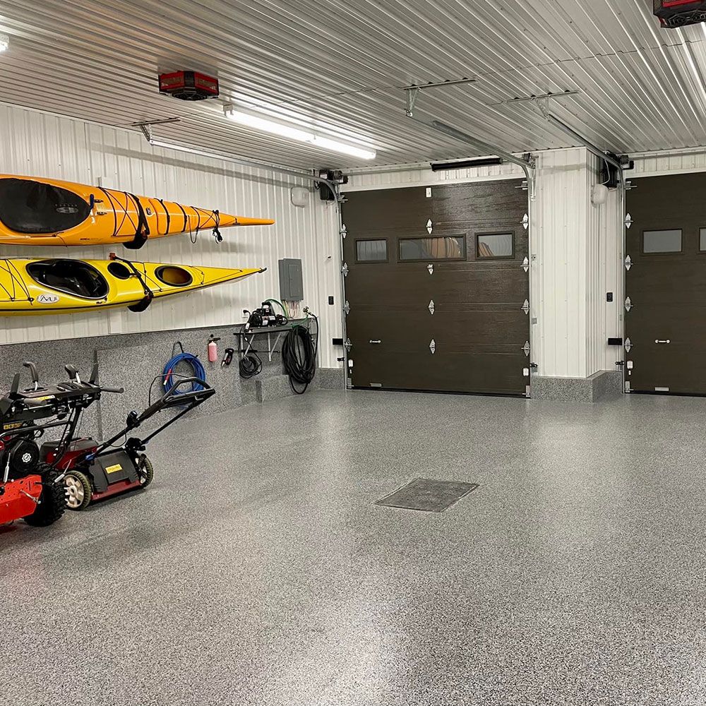 Garage avec plancher d'époxy à flocons, kayaks et outils rangés au mur